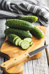 Sliced fresh green cucumbers on cutting board.