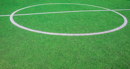 Obraz premium The centre of soccer field with artificial green grass and white lines near the school. Amateur football field. Sunny summer day