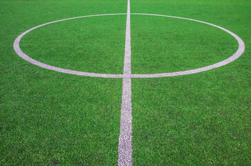 The centre of soccer field with artificial green grass and white lines near the school. Amateur football field. Sunny summer day