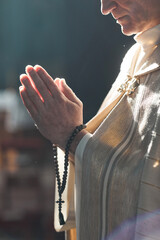Close-up of priest with rosary beads praying during ceremony