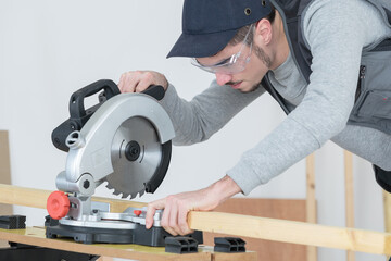 carpenter using circular saw for wood