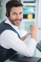 smiling male call center operator doing his job with headset