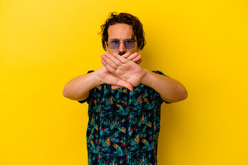 Young caucasian man wearing summer clothes isolated on yellow background doing a denial gesture