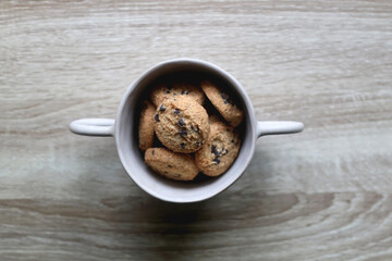 Bowl of chocolate chip cookies on wooden table. Flat lay.