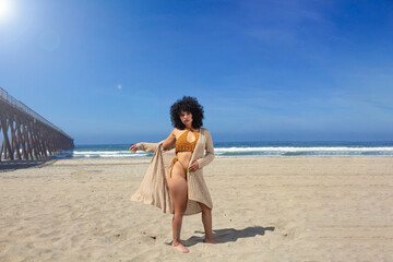 sexy and beautiful hispanic model with curly hair wearing bikini at the beach. Mexican woman