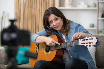 Fototapeta na wymiar young female guitar blogger recording video tutorial