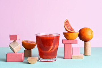 Red orange juice in a glass with geometric shapes. Pop trend 2021. The concept of beautiful food.