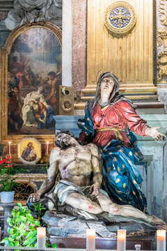 Close-up on colorful sculpture of Mary crying over dead Jesus body, decorating church interior in Rome