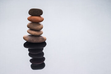 Fototapeta na wymiar Stones stacked on top of each other with reflection. Balance and stability, concept