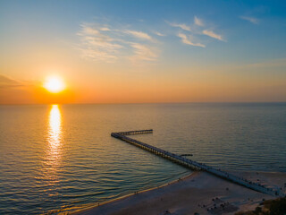 Obraz premium Aerial view of Palanga bridge to the Baltic sea and a sunset in horizon