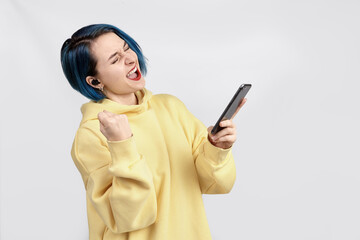 A female in yellow hoody holding wireless earphones