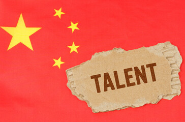 Against the background of the Chinese flag lies cardboard with the inscription - talent