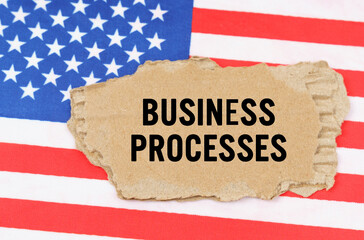 On the US flag lies a cardboard box with the inscription- BUSINESS PROCESSES