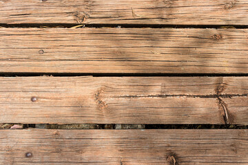 Superficie de madera desgastada vieja con tablas alineadas. Tablones de madera en una pared o piso con vetas y textura. Tonos cálidos. Textura de madera natural
