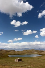 Tulpar Lake with white clouds on blue sky, Kyrgyzstan 