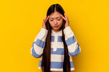 Young chinese woman isolated on yellow background touching temples and having headache.