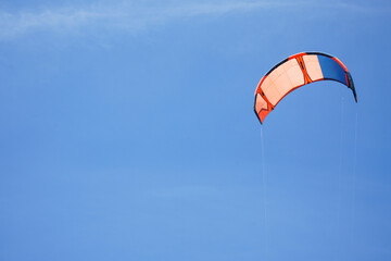 Kitesurfing on a background of blue sky, place for text