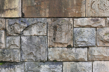 Old weathered wall made of granite stones, abstract background.