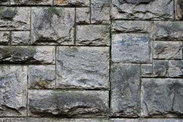 Old weathered wall made of granite stones, abstract background.