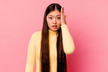 Young chinese woman isolated on pink background being shocked, she has remembered important meeting.