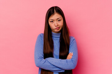 Fototapeta premium Young chinese woman isolated on pink background who is bored, fatigued and need a relax day.