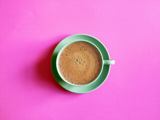 Blue coffee cup and saucer shot on pink surface. Top view, from above, flat lay. Coffee break background.