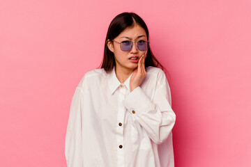 Young chinese woman isolated on pink background having a strong teeth pain, molar ache.