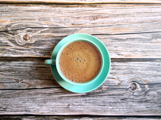 Blue coffee cup and saucer shot on wooden surface. Top view, from above, flat lay. Coffee break background.