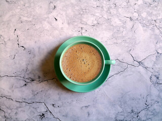 Blue coffee cup and saucer shot on marble surface. Top view, from above, flat lay. Coffee break...