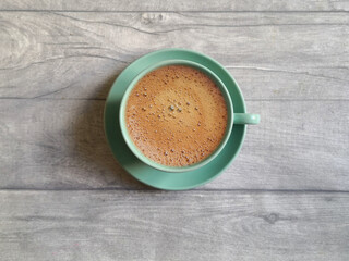 Blue coffee cup and saucer shot on grey wooden surface. Top view, from above, flat lay. Coffee break background.
