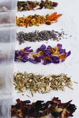 Many dry tea in teabag sachet in a row on bright background. Mix of drink ingredient set. Tea package wrap