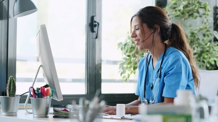 Video of beautiful female doctor talking with earphone while explaining medical treatment to patient through a video call with computer in the consultation. - Powered by Adobe