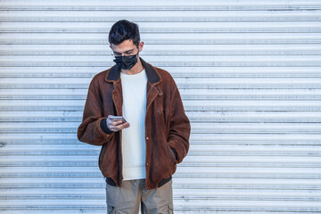 man with mask and mobile phone on the street