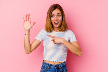 Young caucasian woman isolated on pink background smiling cheerful showing number five with fingers.