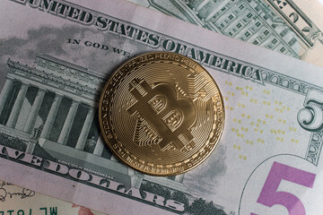Bitcoin and five American dollar bill close-up.