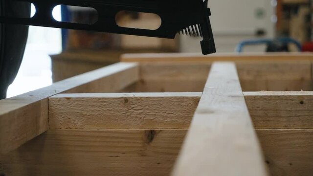 arisant travaillant le bois avec cloueuse pneumatique