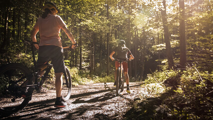Two girls on mtb bikes. Mother and daughter riding on a forest trail.