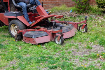 Machine for cutting lawns on lawn mower on green grass in garden.