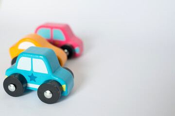 Wooden toy cars with yellow, blue and pink colors with white background