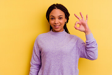 Young african american woman isolated on yellow background cheerful and confident showing ok...