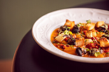 tomato based seafood meal served in a decorative and elegant white dish