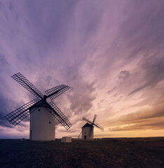 molinos de viento de don quijote al atardecer con el cielo nublado