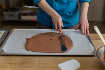 the confectioner spreads the dough with a pastry spatula