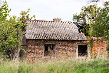 Fototapeta na wymiar Old village house near Krakow. Abandoned brick house after fire. Old slate and charred beams.