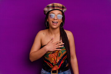 Young african american woman isolated on yellow background Young african american woman isolated on yellow background laughs out loudly keeping hand on chest.
