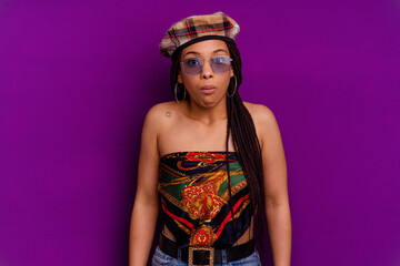 Young african american woman isolated on yellow background Young african american woman isolated on yellow background shrugs shoulders and open eyes confused.