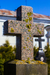 Old stone cross in the old cemetery. Red granite cross with lichen.