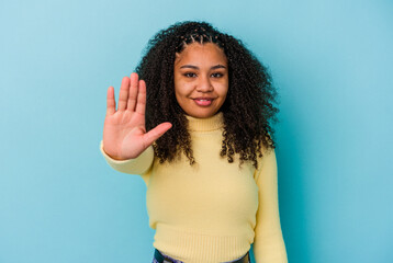 Young african american woman isolated on blue background smiling cheerful showing number five with fingers.