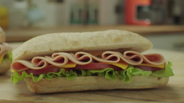 Bread falling on a sandwich with salami. Beef salami sandwich at the dinner table. 