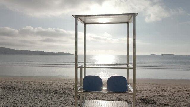 V&iacute;deo zoom in de un puesto de socorriste vac&iacute;o en una playa al atardecer